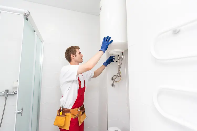 Tecnico che installa un nuovo scaldabagno in un bagno