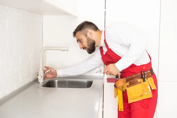 Idraulico che installa un nuovo rubinetto da cucina
